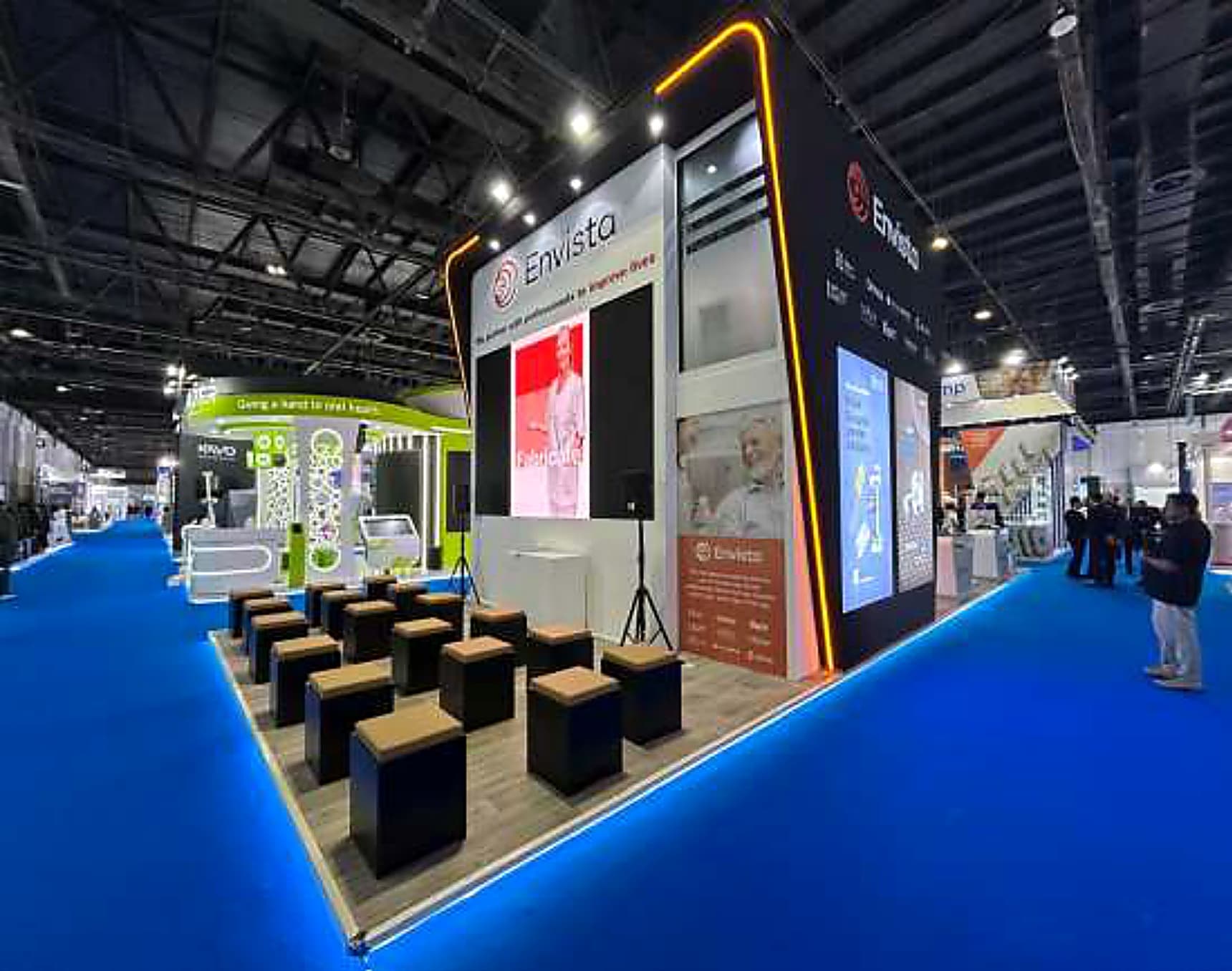 Dental and medical technology stand with a seated presentation theatre and an illuminated yellow perimeter