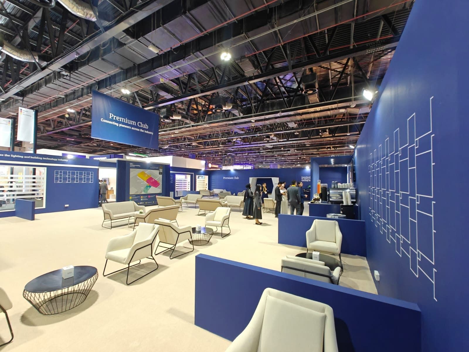 Press and networking lounge built by IMI, a hanging banner above seating and a line-drawn feature wall
